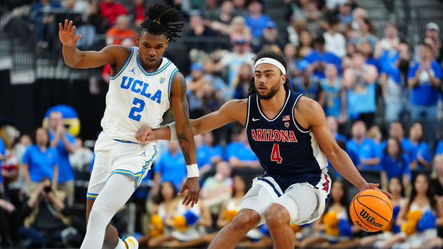 Arizona Wildcats guard Kylan Boswell dribbles against UCLA Bruins guard Dylan Andrews.
